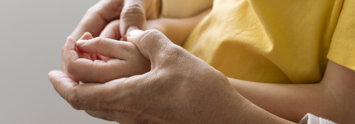 Grandparent holding child's hands